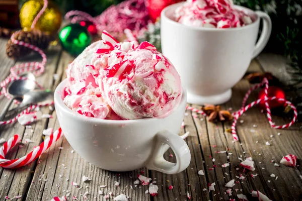 Christmas dessert, Homemade Peppermint Candy Cane Ice Cream in two cups, old wooden background with xmas decorations copy space