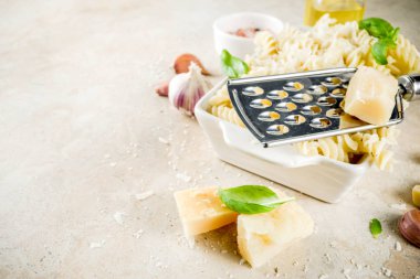 İtalyan gıda, Düdük makarna rendelenmiş parmesan peyniri ve fesleğen, taş masa lambası ile kopyalama alanı üstten görünüm