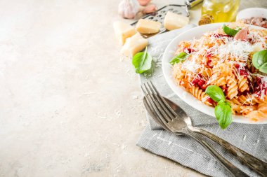 İtalyan gıda, Düdük makarna salça, rendelenmiş parmesan peyniri ve fesleğen, taş masa lambası ile kopyalama alanı üstten görünüm