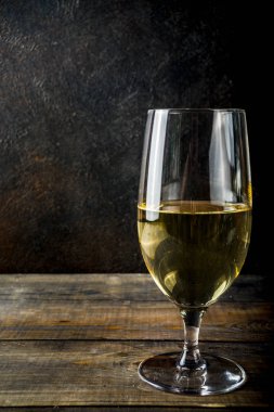 Koyu arka plan kopya alanı üzerinde bir bardak beyaz şarap