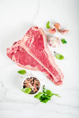 Çiğ taze et, t-bone Biftek Biftek baharat ve otlar üzerinde kesme tahtası, beton masa üstü görünümü ile kopyalama alanı