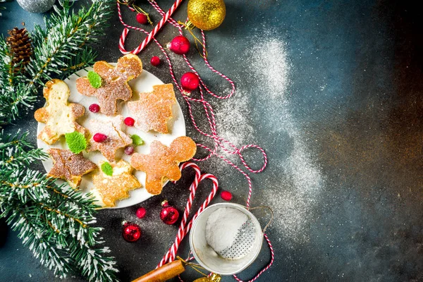 Creative idea for xmas breakfast, funny christmas pancakes in form of gingerbread man, christmas tree and star, dark concrete background with xmas decorations, top view