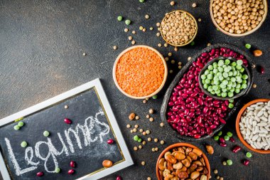 Baklagiller - fasulye, soya fasulyesi, nohut, mercimek, yeşil bezelye çeşitli ürün yelpazesine. Sağlıklı beslenme kavramı. Bitkisel proteinler. Karanlık beton arka plan kopya alanı üstten görünüm