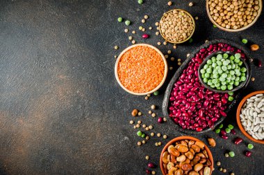 Baklagiller - fasulye, soya fasulyesi, nohut, mercimek, yeşil bezelye çeşitli ürün yelpazesine. Sağlıklı beslenme kavramı. Bitkisel proteinler. Karanlık beton arka plan kopya alanı üstten görünüm