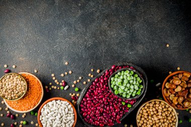 Baklagiller - fasulye, soya fasulyesi, nohut, mercimek, yeşil bezelye çeşitli ürün yelpazesine. Sağlıklı beslenme kavramı. Bitkisel proteinler. Karanlık beton arka plan kopya alanı üstten görünüm