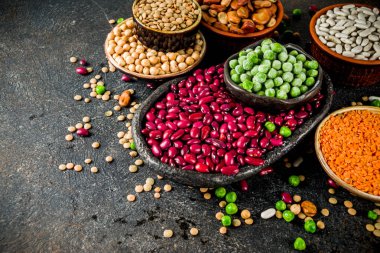 Baklagiller - fasulye, soya fasulyesi, nohut, mercimek, yeşil bezelye çeşitli ürün yelpazesine. Sağlıklı beslenme kavramı. Bitkisel proteinler. Karanlık beton arka plan kopya alanı üstten görünüm