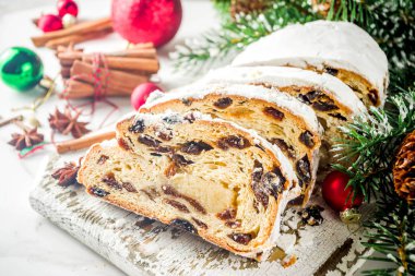 Geleneksel Avrupa Noel pasta, stollen, baharatlar ve kurutulmuş meyve kokulu ev pişmiş. Ahşap masanın üzerine dilimlenmiş xmas ile ağaç dalları ve süslemeleri, kopyalama alanı