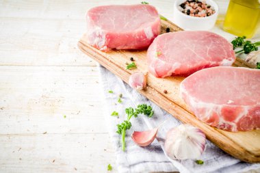 Pişirme et akşam yemeği arka plan. Çiğ taze et, domuz eti kemiksiz biftek, baharatlar, bitkiler, zeytinyağı, Beyaz ahşap zemin üzerinde görünümü top