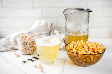 Nohut suyu aquafaba, sıvı su tuzlu su, vegan tarifi için pişirme içinde Değiştir yumurta. Vegan diyet içecek, beyaz mermer arka plan kopya alanı