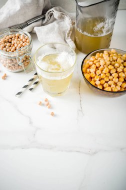 Nohut suyu aquafaba, sıvı su tuzlu su, vegan tarifi için pişirme içinde Değiştir yumurta. Vegan diyet içecek, beyaz mermer arka plan kopya alanı