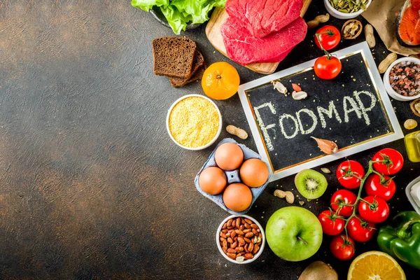 Sağlıklı bir diyet yemek. Çeşitli düşük fodmap malzemeler seçimi - et, sebze, berry, meyve, tahıl, Trendy sağlıklı yaşam konsepti. Karanlık paslı arka plan kopya alanı üstten görünüm