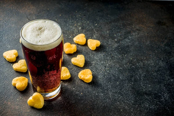 Beer and heart snack, treatment idea for Valentine\'s day, dark rusty background copy space