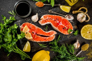 Çiğ Somon Balık biftek ile limon, otlar, zeytin yağı, ızgara, kayrak kesme tahtası, karanlık paslı arka plan kopya alanı için hazır