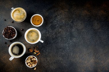 Üç kahve fincanı, fasulye, kahve ve kahverengi şeker zemin. Koyu mavi arka plan üstten görünüm alanı, metniniz için