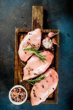 Ham taze tavuk göğsü fileto baharat ve biberiye koyu mavi beton zemin, metin kopyalama yeri olan üstten görünüm
