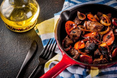 Soğan ve havuç alakart tavada, karanlık paslı tablo kopya alanı ile kavrulmuş ya da ızgara sığır eti karaciğer