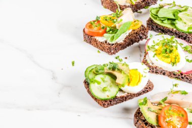 Çeşitli Danimarka açık sandviçle Smorrebrod balık, yumurta ve taze sebze, beyaz mermer zemin kopya alanı kümesi