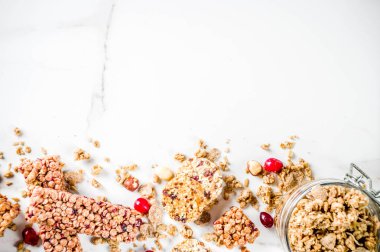 Çok tahıl granola müsli bar. Sağlıklı yiyecek, kurutulmuş meyveler, fındık, tahıl ve bal ile diyet snack. Bir beyaz mermer zemin, üstten görünüm Kopyala yer metin için.