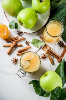 Ev yapımı elma reçel veya sosu, yeşil elma ve baharatlar, beyaz mermer zemin kopya alanı ile