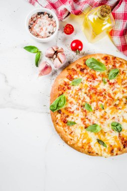 Ev yapımı dilimlenmiş peynirli klasik İtalyan pizza malzemeleri ve zeytinyağı, beyaz mermer zemin kopya alanı üstten görünüm