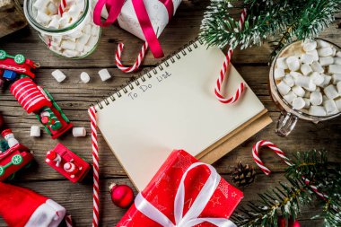 Noel kavramı, xmas tatil için hazırlık için istek listesi, santa harf not etmek. Yapılacaklar listesi için ile sıcak sıcak çikolata Kupası, Noel ağacı dekor, çam dalları. Eski ahşap masa kopya alanı üstten görünüm