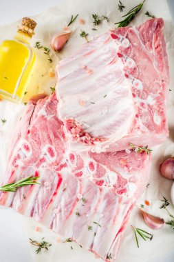 Çiğ et, domuz kaburga otlar ve baharatlar, beyaz mermer zemin ile alanı kopyalayın.