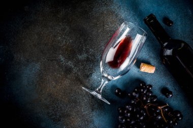 Cam ve üzüm ile kırmızı şarap şişesi, koyu arka plan kopya alanı üstten görünüm seçici odak