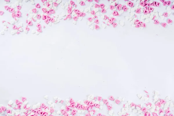 Valentine\'s sweets background, white background with sugar hearts sweet sprinkles, copy space top view, layout on white