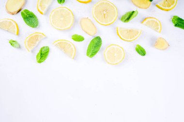 Mojito, limonata kokteyl veya ekşi infüzyon su madde. Dilimlenmiş limon, zencefil ve nane yaprakları, beyaz arka plan üstten görünüm kopya alanı düzeni ile Flatlay