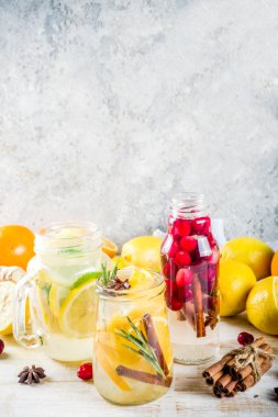 Çeşitli sonbahar ve kış serinletici su, tatlı ekşi sağlıklı içecekler portakal, bal, kızılcık, nane, biberiye, tarçın ve baharatlar, Beyaz ahşap arka plan kopya alanı ile infüzyon