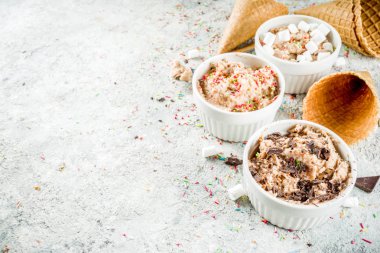 Yenilebilir ham kurabiye hamuru, gözleme dondurma koniler gri taş zemin, kopya alanı üzerine ile şekerli modern tatlı