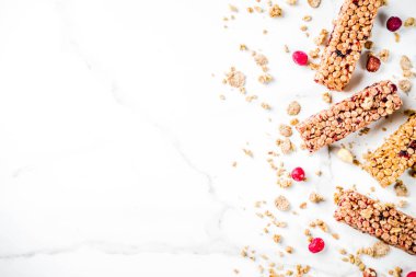 Çok tahıl granola müsli bar. Sağlıklı yiyecek, kurutulmuş meyveler, fındık, tahıl ve bal ile diyet snack. Bir beyaz mermer zemin, üstten görünüm Kopyala yer metin için.