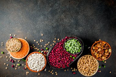 Baklagiller - fasulye, soya fasulyesi, nohut, mercimek, yeşil bezelye çeşitli ürün yelpazesine. Sağlıklı beslenme kavramı. Bitkisel proteinler. Karanlık beton arka plan kopya alanı üstten görünüm