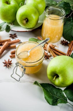 Ev yapımı elma reçel veya sosu, yeşil elma ve baharatlar, beyaz mermer zemin kopya alanı ile