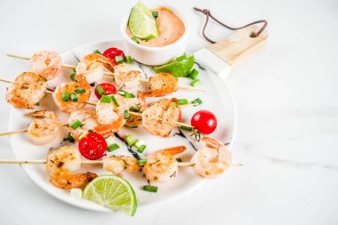 Deniz ürünleri kebap, sos, kireç, soğan ve domates, karides şiş şifreli beyaz mermer arka plan kopya alanı üstten görünüm