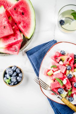 Yaz gıda kavramı, beyaz peynir, yaban mersini, avokado ve nane, beyaz mermer zemin kopya alanı ile taze soğuk karpuz salatası
