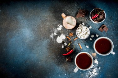 Sıcak çikolata bardak, çikolata, şeker, lokum, kırmızı biber ve baharat adet kırık. Koyu mavi beton arka plan üstten görünüm alanı