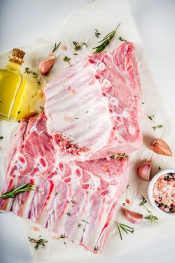 Çiğ et, domuz kaburga otlar ve baharatlar, beyaz mermer zemin ile alanı kopyalayın.