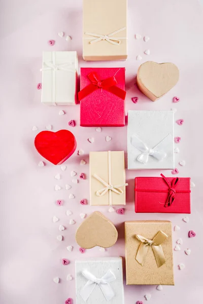 Valentines day gifts boxes background, frame for holiday greeting card background, with confetti  candy hearts, flat lay, top view, copy space