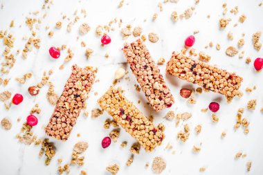 Çok tahıl granola müsli bar. Sağlıklı yiyecek, kurutulmuş meyveler, fındık, tahıl ve bal ile diyet snack. Bir beyaz mermer zemin, üstten görünüm Kopyala yer metin için.