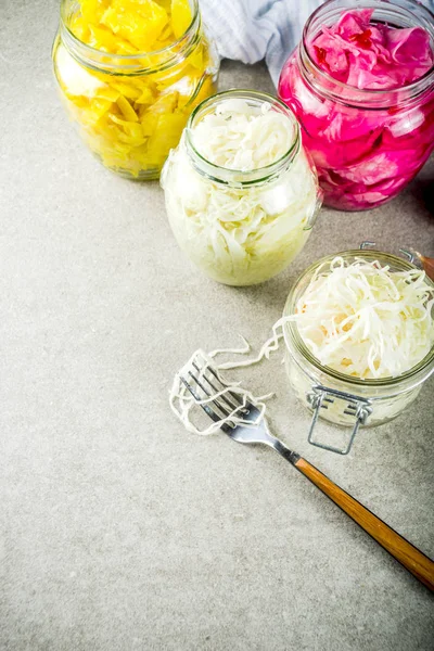 Fermented preserved vegetarian food, Various Sauerkraut preserving in glass jars. Three types homemade Sauerkraut on grey stone table. Copy space.