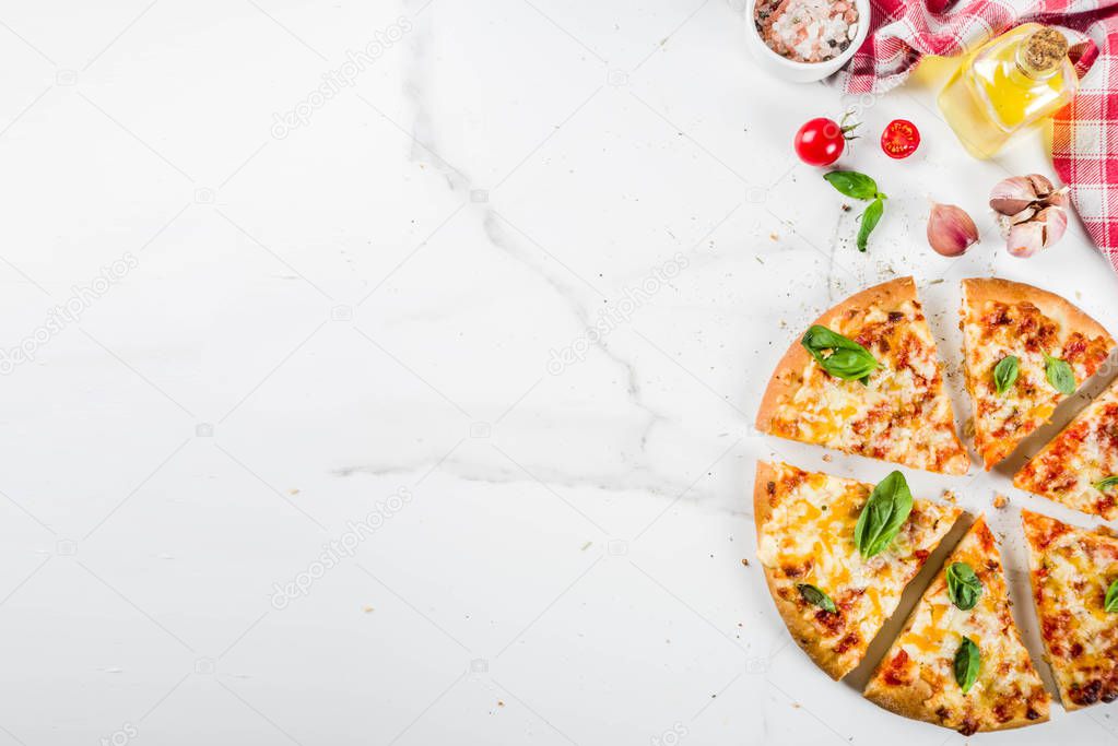 Homemade sliced cheesy classic italian pizza with ingredients and olive oil, white marble background copy space top view