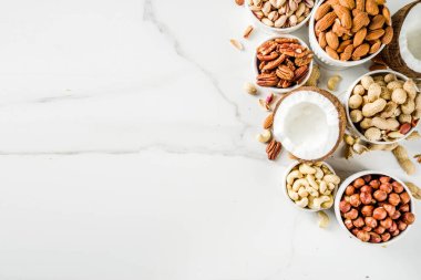 Fındık - ceviz, pecans, fıstık, fındık, Hindistan cevizi, badem, kaju fıstığı, çanaklar, beyaz mermer masa üstü görünümün türleri