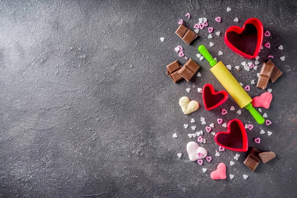 情人节烘焙的概念 糖果和烤烹饪的背景为情人节 与滚针 饼干切割机 巧克力 黑色混凝土桌面视图复制空间 — 图库照片