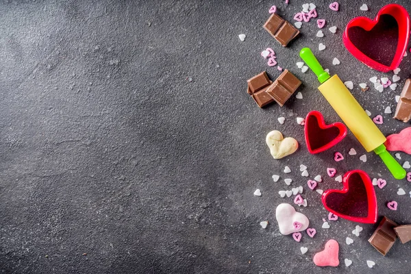 情人节烘焙的概念 糖果和烤烹饪的背景为情人节 与滚针 饼干切割机 巧克力 黑色混凝土桌面视图复制空间 — 图库照片