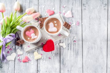 Sevgililer günü fikirleri tedavi eder, iki fincan sıcak çikolata ile marshmallow kalpleri ile kırmızı pembe beyaz çikolata parçacıkları, şeker parçacıkları, eski ahşap arka plan fotokopi alanı üst görünümü