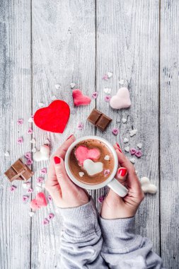 Kız sıcak çikolata hatmi kalpler, kırmızı pembe beyaz renk ile çikolata parçaları, şeker sprinkles, eski ile ahşap arka plan kopya alanı üstten görünüm, eller pictute flatlay eller