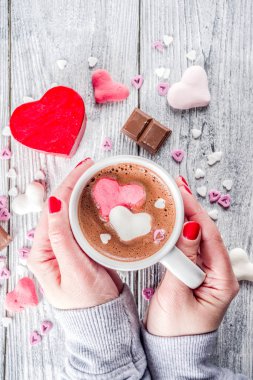 Kız sıcak çikolata hatmi kalpler, kırmızı pembe beyaz renk ile çikolata parçaları, şeker sprinkles, eski ile ahşap arka plan kopya alanı üstten görünüm, eller pictute flatlay eller