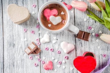 Sevgililer günü fikirleri tedavi eder, iki fincan sıcak çikolata ile marshmallow kalpleri ile kırmızı pembe beyaz çikolata parçacıkları, şeker parçacıkları, eski ahşap arka plan fotokopi alanı üst görünümü