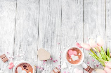 Sevgililer günü fikirleri tedavi eder, iki fincan sıcak çikolata ile marshmallow kalpleri ile kırmızı pembe beyaz çikolata parçacıkları, şeker parçacıkları, eski ahşap arka plan fotokopi alanı üst görünümü